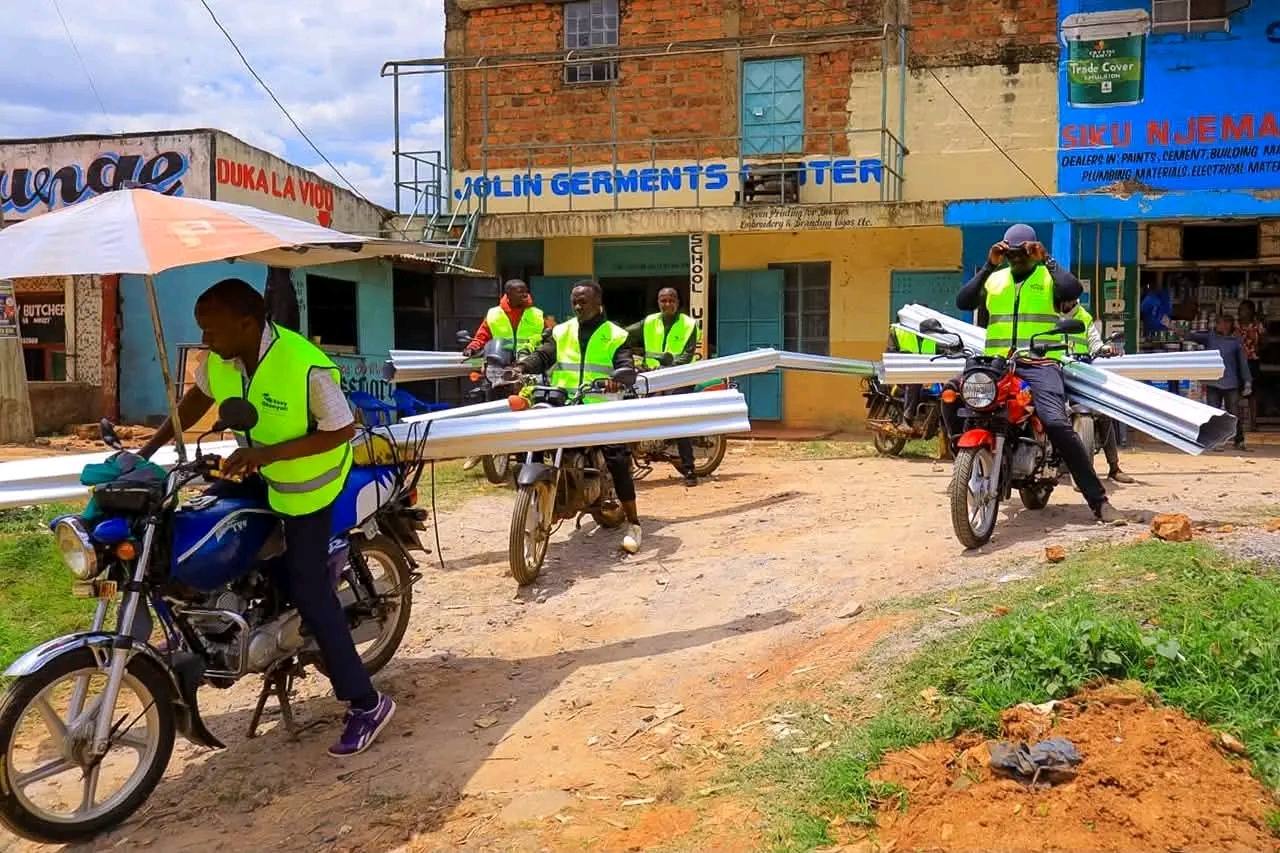 Team moving iron sheets through Kitutu Chache South